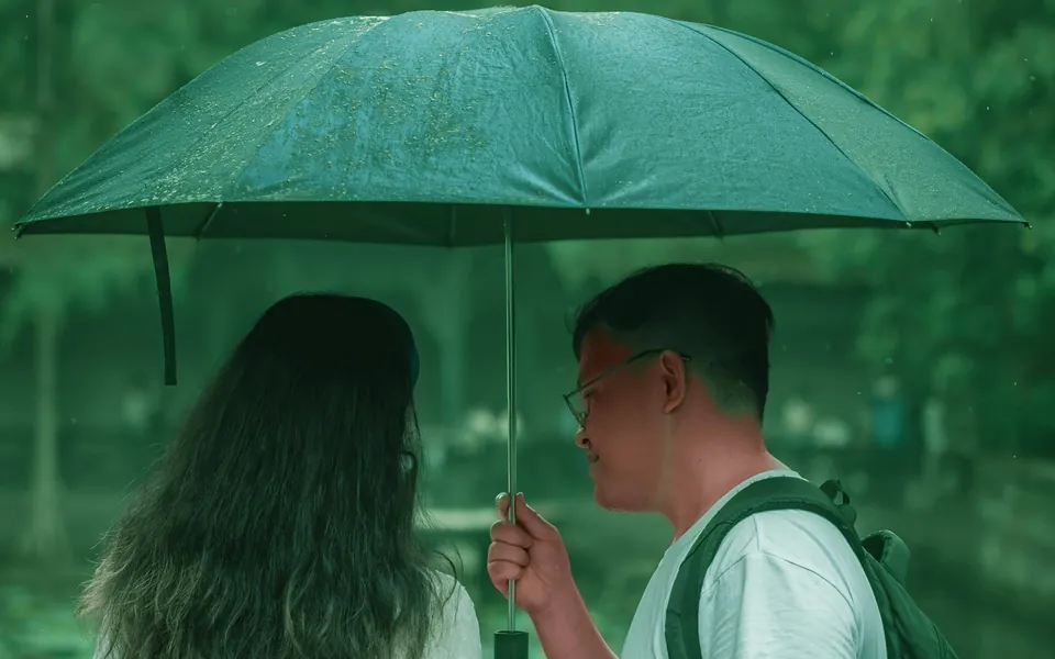 下雨天，两个人共撑一把伞